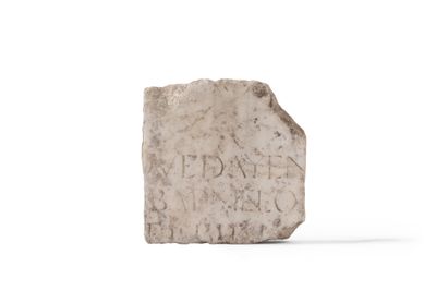 un bloc de pierre portant une inscription sur une surface blanche