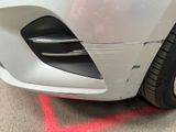 a close up of a car ' s front bumper with a red line painted on the side of it