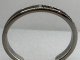 un gros plan d'un bracelet manchette en argent orné de pierres noires