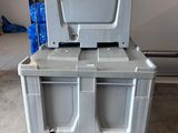 a large gray box with two bins on top of it