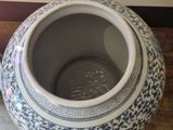 a blue and white vase sitting on a table next to another vase