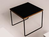 a small table with a black top on a white surface