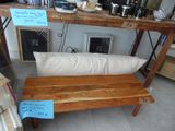 un banc en bois sur lequel est posé un coussin, devant une table