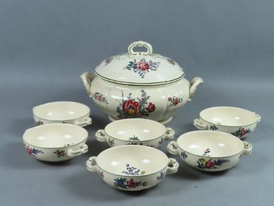six tasses et une soucoupe avec un couvercle posées sur une table