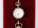 three different types of pocket watches displayed in a display case