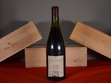 a bottle of wine sitting on a table next to two wooden boxes