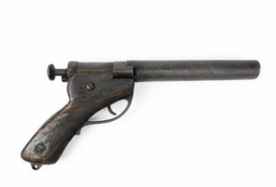 gros plan d'un pistolet sur une surface blanche