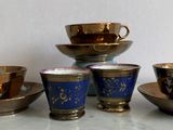 five cups and saucers sitting on a table