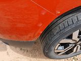 a close up of a car ' s tire on a dirt road