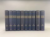 six blue books with gold lettering on them sitting on a white surface
