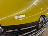 a close up of a yellow truck with a sticker on it ' s hood
