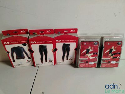 trois cartons contenant des vêtements assortis, posés les uns à côté des autres sur une table