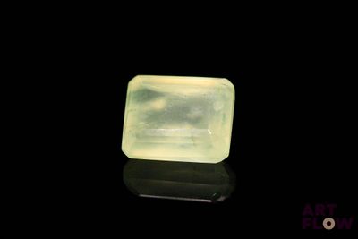 une image représentant une pierre de jade verte posée sur une surface noire