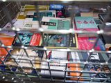 a wire basket filled with books on a table