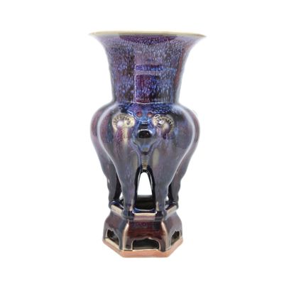 un vase violet posé sur un socle