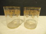 deux verres ornés de motifs dorés posés sur une table