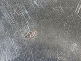 a close up of a metal plate with a diamond on it