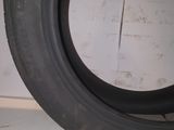 a close up of a tire on the ground with a wall in the background