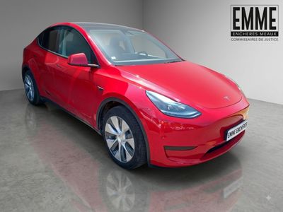 une Tesla Model Y rouge garée dans un garage