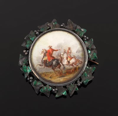 a picture of a broochle with a picture of a man riding a horse