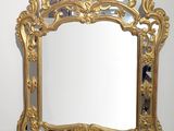 un miroir doré accroché au mur de la pièce