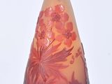 a glass vase with flowers on it on a white surface