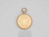 an antique gold pocket watch with a medallion on the front