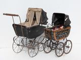 an old fashioned baby carriage with a baby in it