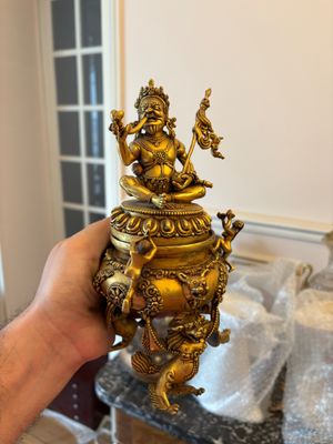 une personne tenant une statue en or dans la main