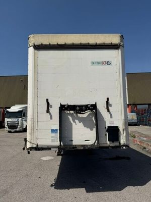 a white truck parked in a parking lot with other trucks