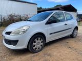 a picture of a small white car parked in a dirt lot