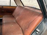 a dirty seat in the back of an old car