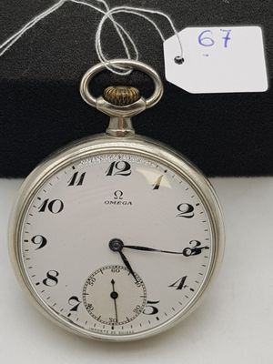 une montre de poche en argent exposée sur une table