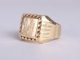 an image of a gold signet ring on a white surface