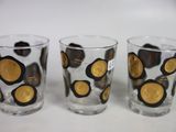 three glasses with gold and black designs on them