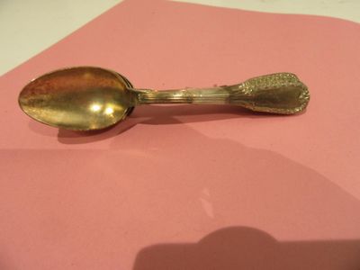 a gold spoon on a pink napkin on a table