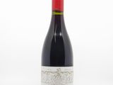une bouteille de vin posée sur une table blanche