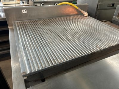 une grande grille métallique sur laquelle est fixé un tuyau jaune