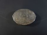 a silver coin sitting on top of a black surface