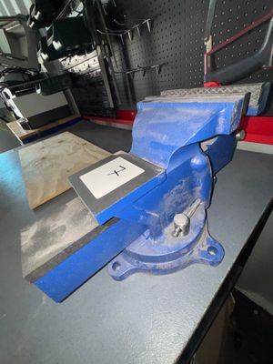 un étau bleu posé sur une table dans un atelier