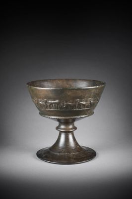 a bronze bowl with a design on the rim