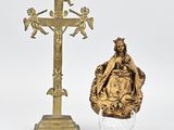 une statue représentant une femme assise sur une chaise à côté d'une croix