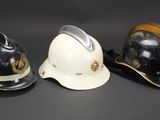 three helmets are lined up in a row on a black surface