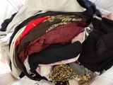 a pile of clothes sitting on top of a bed