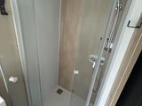 a bathroom with a shower, sink, and mirror in it
