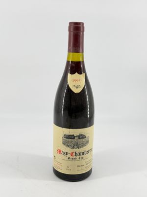 a bottle of red wine sitting on top of a white table