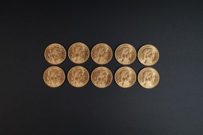 Plusieurs pièces d'or sont alignées sur une surface noire