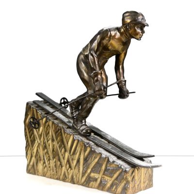 bronze statue of a man on skis on top of a ramp