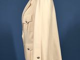 a white jacket on a mannequin stand against a blue background