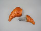 un croissant et un couteau posés sur une table